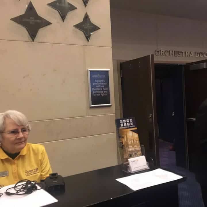 volunteer in gold at assistive listening devices booth