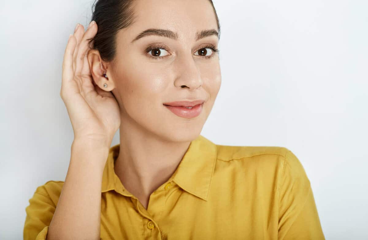 Woman Cupping Ear To Enhance Hearing Momentarily